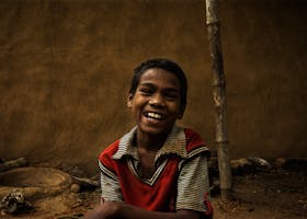 A joyful child smiling outdoors in Ranchi, India, showcasing happiness and innocence.